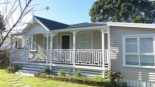 A single-story house with a porch, a front door, and a small front yard with a brick pathway. - Modern Home in Convenient Location (Auckland)