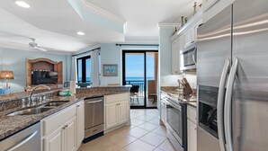 Cozinha moderna com eletrodomésticos de aço inoxidável, uma ilha grande e vista para o exterior.