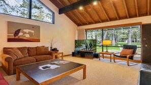 A living room with a sofa, coffee table, TV, and a chair.