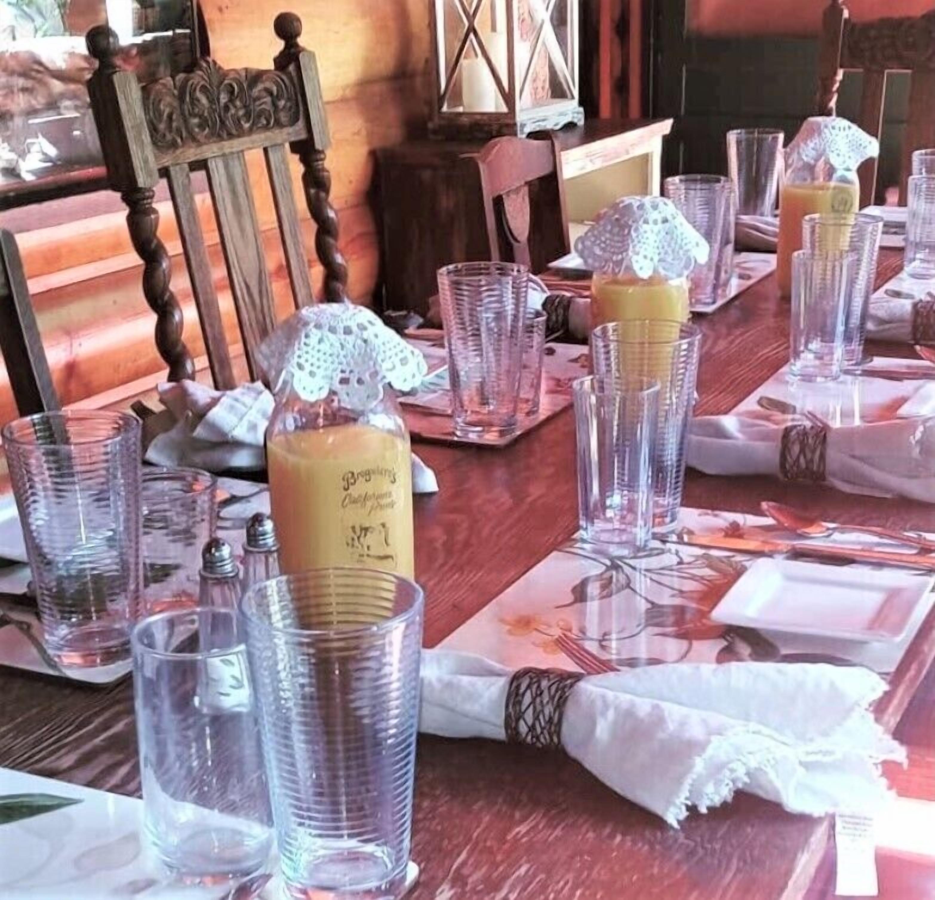 A table set for dining with clear glassware, a bottle of beverage, and a candle.