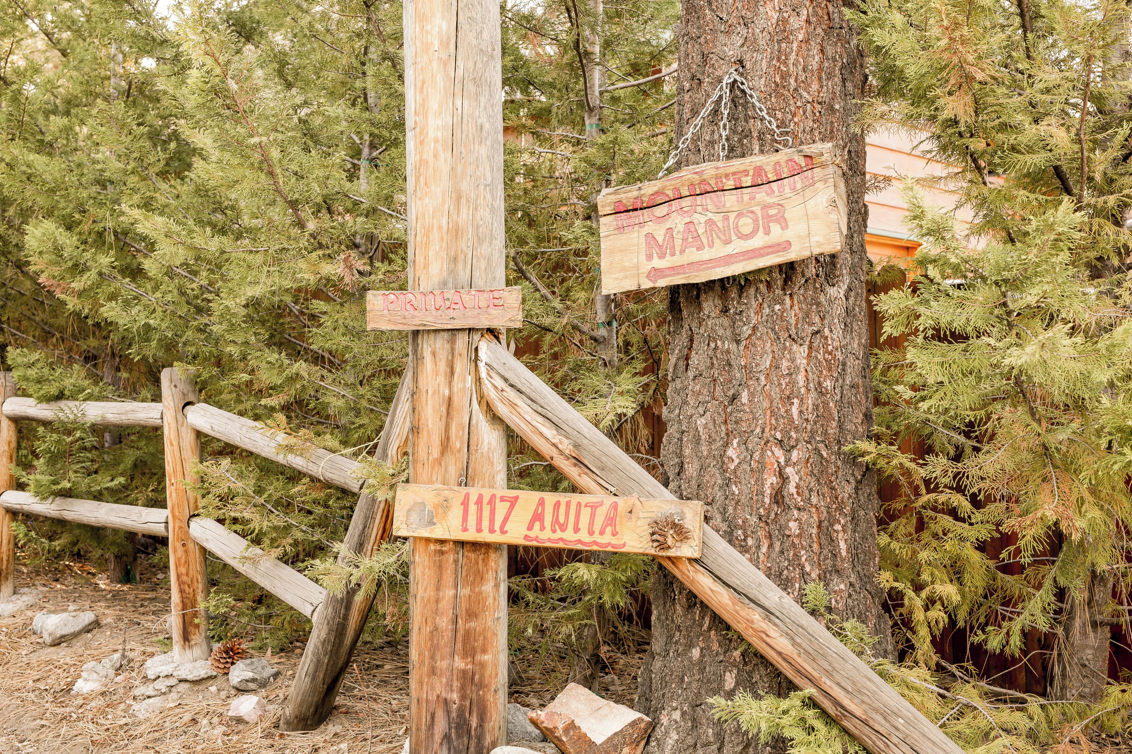 A wooden signpost with directional arrows and the text 'MOUNT MANCOR PRIVATE' and '1117 AMITA' indicating a private property or trail.