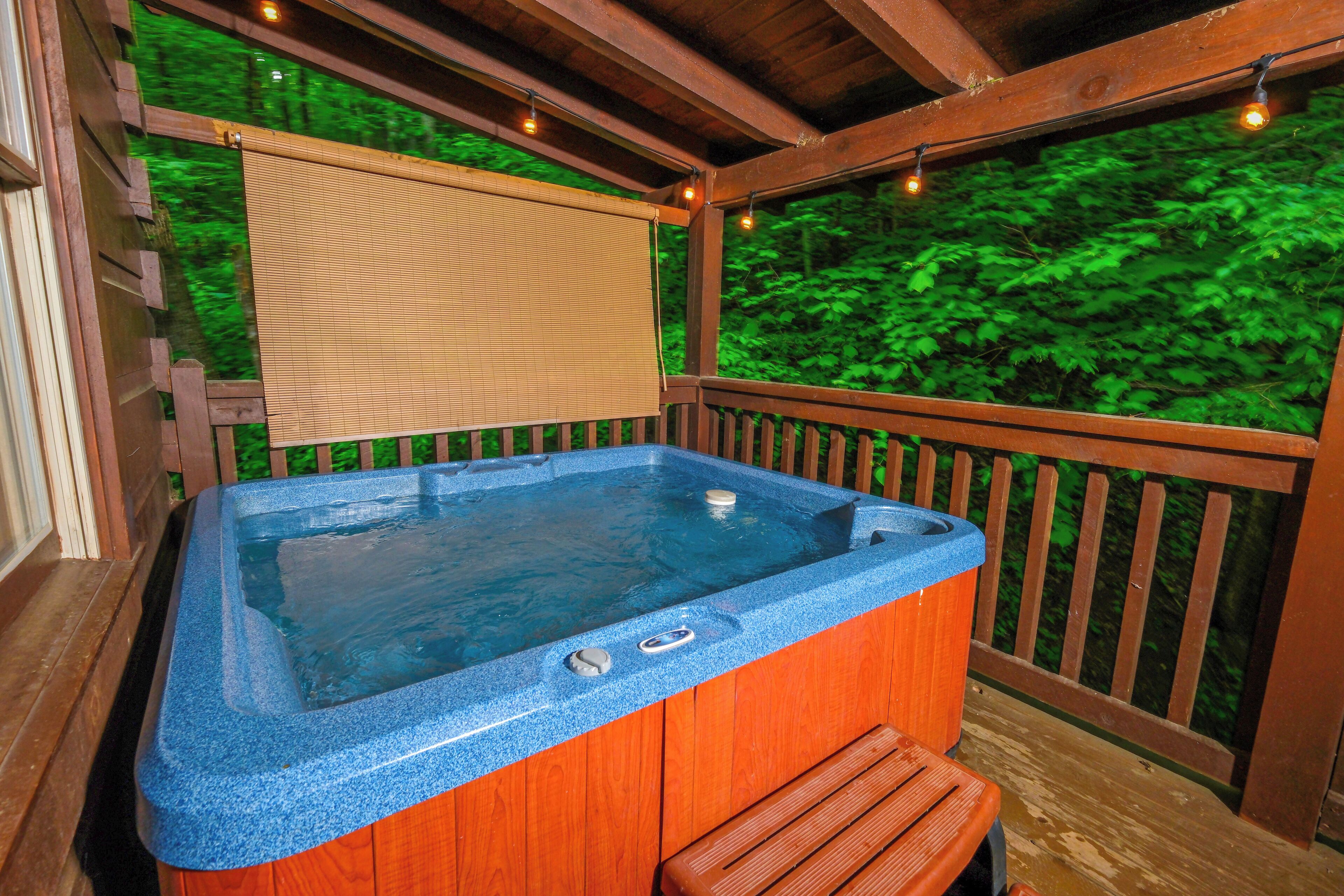 A hot tub with a wooden deck and a view of a forest.