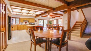 A spacious kitchen with wooden cabinets, a dining area with a large wooden table and chairs, and a staircase leading to an upper level. - 2 Tokatee-Sunriver, Oregon: Hot Tub, BBQ, WiFi, SHARC Aquatics, Tubing Hill, Mt. Bachelor, Golf, Deschutes River, Tennis, Bike Paths (Sunriver)