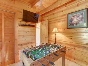 Relax in this inviting room with a foosball table, TV, and framed artwork.