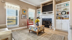 A living room with a fireplace, a television, and a bookshelf.