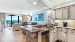 A spacious kitchen with a central island, granite countertops, and white cabinetry. - Mesmerizing Views in this Gulf Front Condo! (Orange Beach)