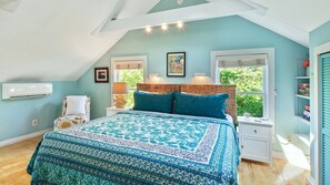Un dormitorio con una cama grande, una mesita de noche, una silla y una ventana con persianas.