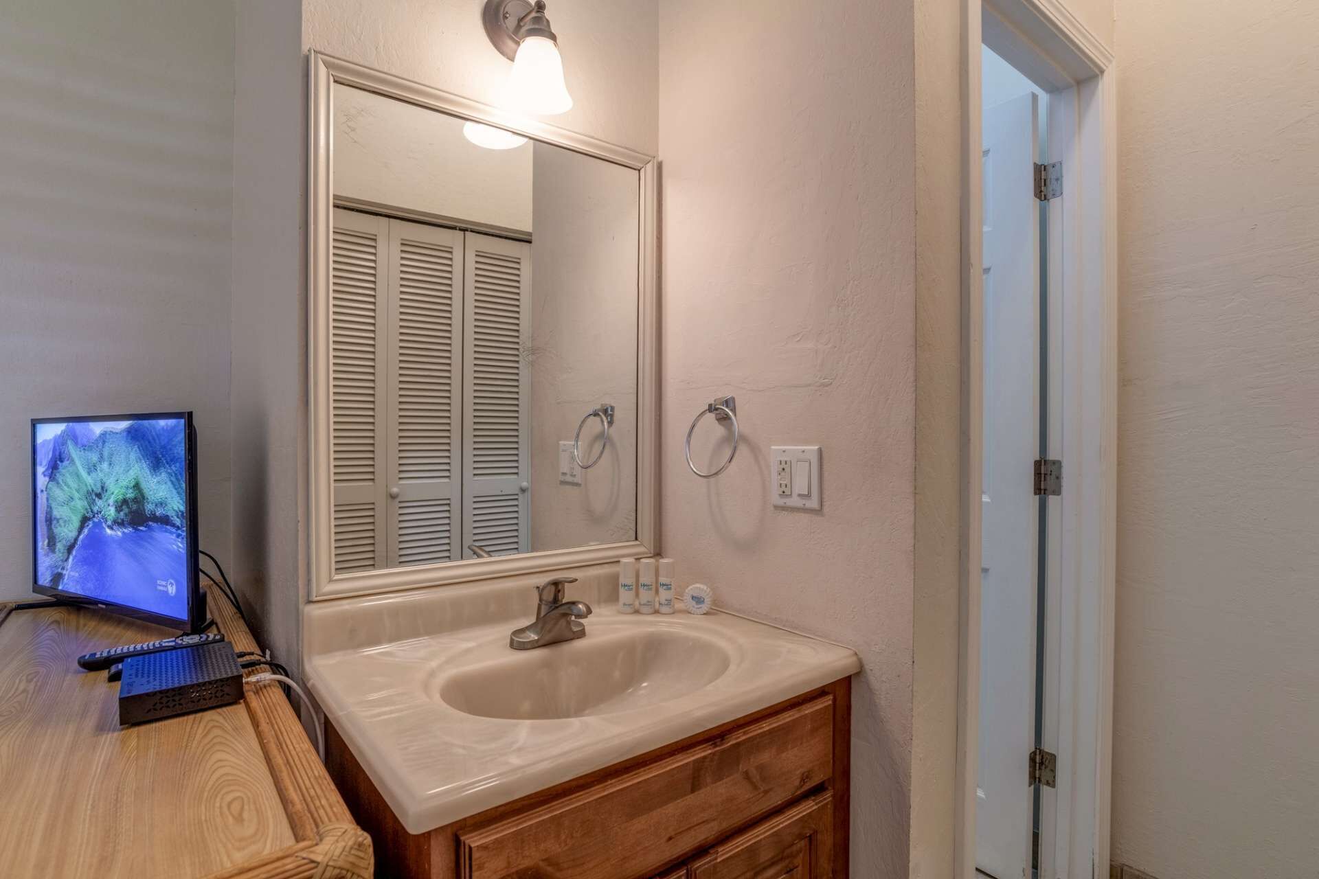 A bathroom with a sink, mirror, and toilet.