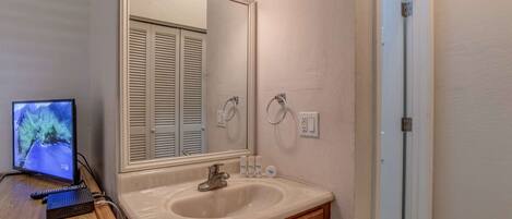A bathroom with a sink, mirror, and toilet.