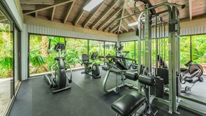 A gym with various exercise equipment, large windows, and a view of greenery. - **FOLLOW THE SUN** Ocean Condo / Pool & Tennis + Last Key White Glove Service... (Key West)