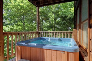 Une terrasse en bois avec un jacuzzi.