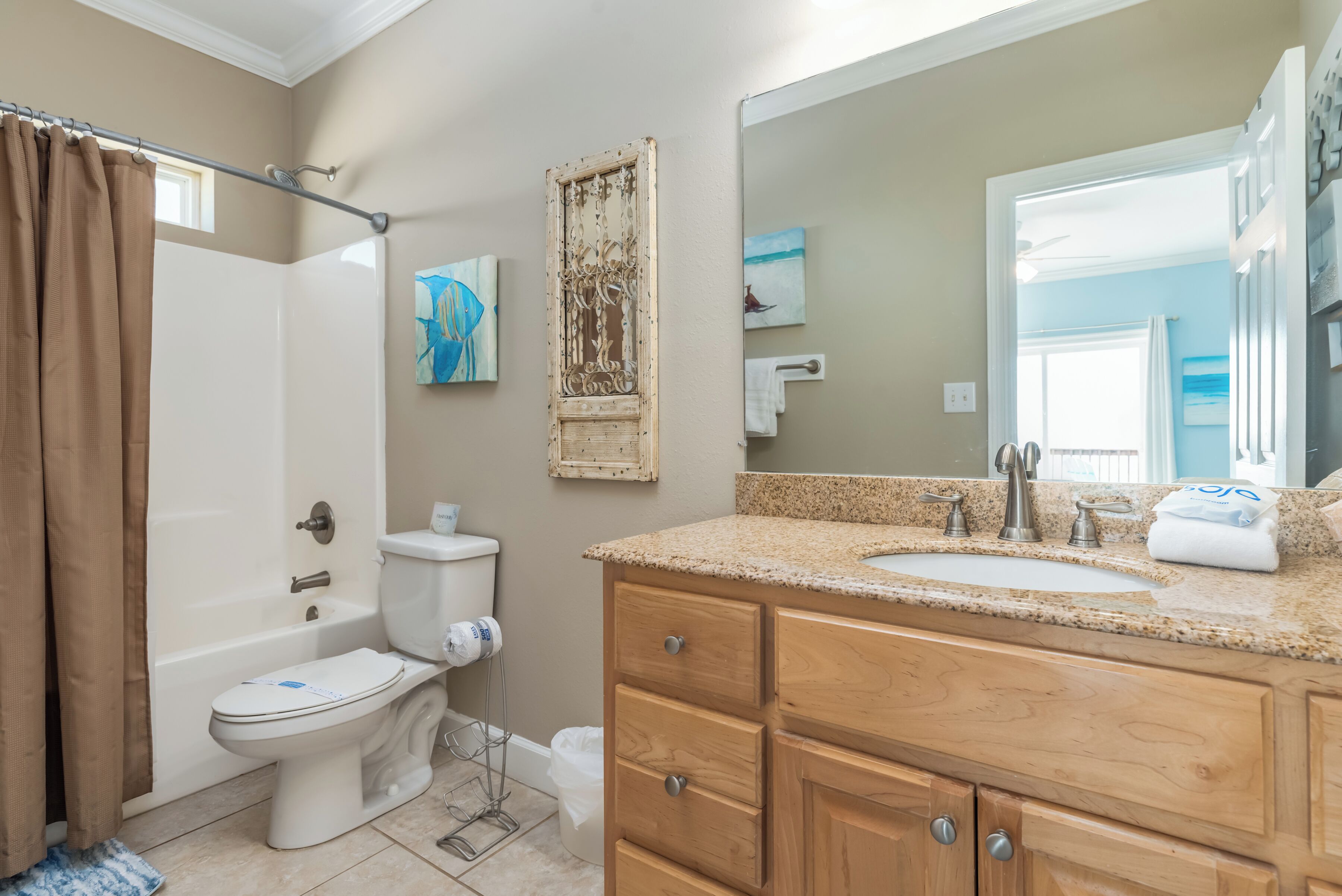 A bathroom with a bathtub, toilet, sink, and wooden vanity.