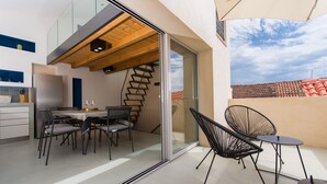 A modern kitchen with a built-in refrigerator, a dining area with a table and chairs, and a staircase leading to an upper level. - Casa Sepia in Trogir old town for up to 6 people (Trogir)