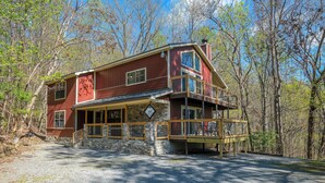 A two-story wooden cabin with a stone foundation, a porch, and a deck. - 5BR in Gatlinburg with hot tub and pool table! 1 free ticket to Dollywood! (Gatlinburg)