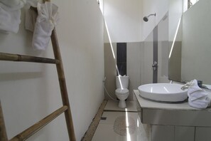 Une salle de bain équipée de toilettes, d’un lavabo et d’un miroir.