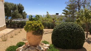 A garden with a large pot, a spherical hedge, and a view of the sea. - Lirios Boutique Luxury Seaview Villa ⭐︎⭐︎⭐︎⭐︎⭐︎ (Benitachell)