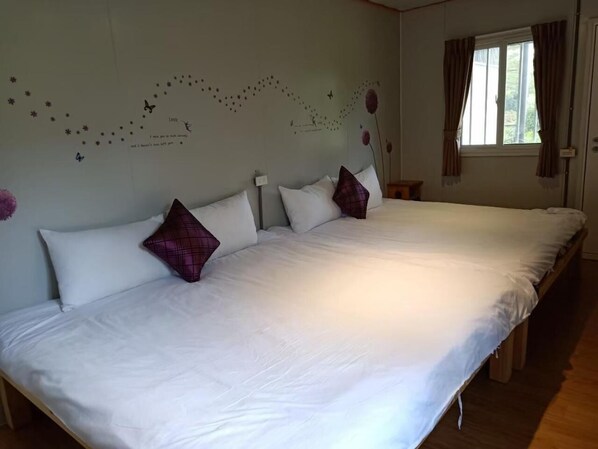 A large bed with white linens and purple pillows, a wall with a star and butterfly decoration, and a window with curtains. - 556Homestay (Tainan)