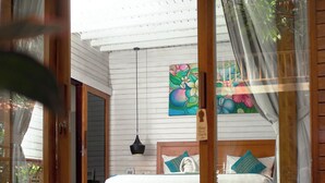 A bedroom with a bed, a nightstand, and a painting on the wall.