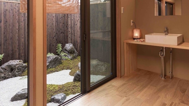 A modern bathroom with a sliding glass door leading to a garden area. - Marikoji Inn Kyoto (Kyoto)