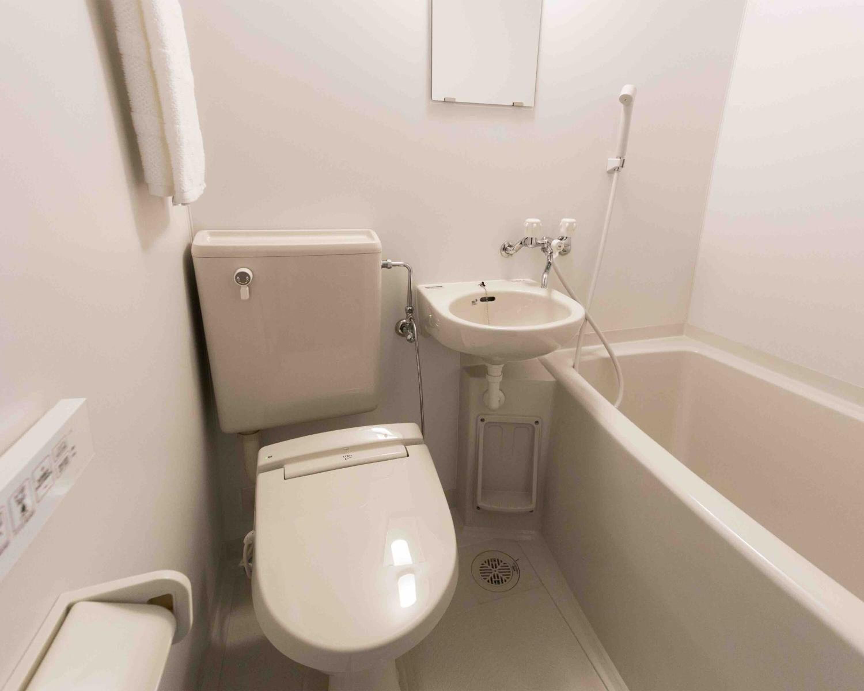 A small, white bathroom with a toilet, sink, and bathtub.