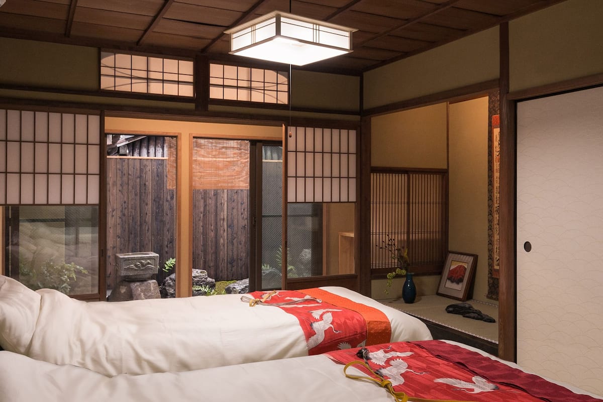 Una tradizionale stanza in stile giapponese con pavimento in tatami, porte scorrevoli e soffitto basso.