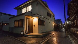 A modern two-story house with a well-lit entrance and a visible garage door. - Marikoji Inn Kyoto (Kyoto)