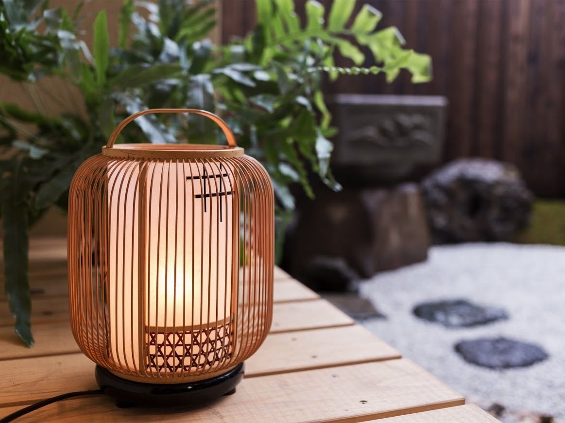 A lantern-style outdoor light fixture on a wooden surface.