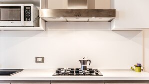 A modern kitchen with a built-in microwave, stainless steel range hood, and a gas stove. - Apartment in Giavera del Montello for up to 4 people (Giavera del Montello)
