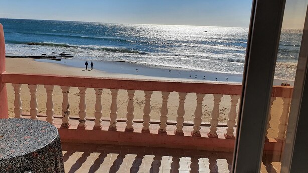 Un balcón con vista a la playa y al océano.