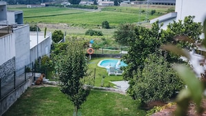 A backyard with a swimming pool, a dog, and a fenced area.
