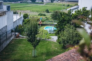 Un jardin avec une piscine, un chien et un espace clôturé.