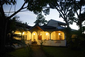 Vista frontal de la propiedad por la tarde o noche