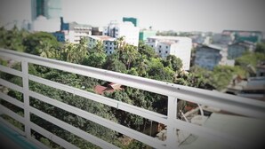 A view from a balcony with a railing, overlooking a cityscape with buildings and greenery. - 121 Hotel Yangon (Yangon)