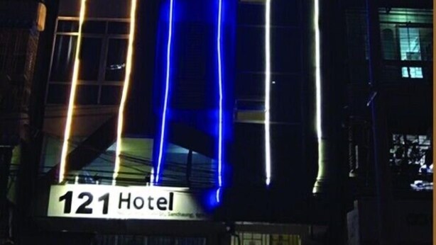 A hotel with a modern facade, featuring illuminated vertical lines in blue and yellow. The hotel's name, "121 Hotel," is visible at the bottom. - 121 Hotel Yangon (Yangon)