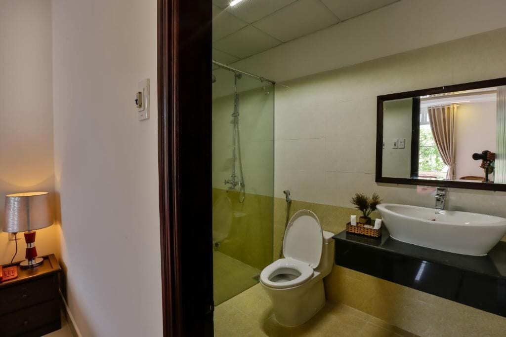 A bathroom with a toilet, a sink, and a glass shower enclosure.