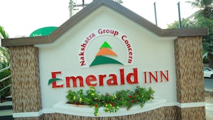 A sign for Emerald Inn with a logo and name.