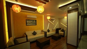 A modern living room with a sofa set, coffee table, and pendant lighting.