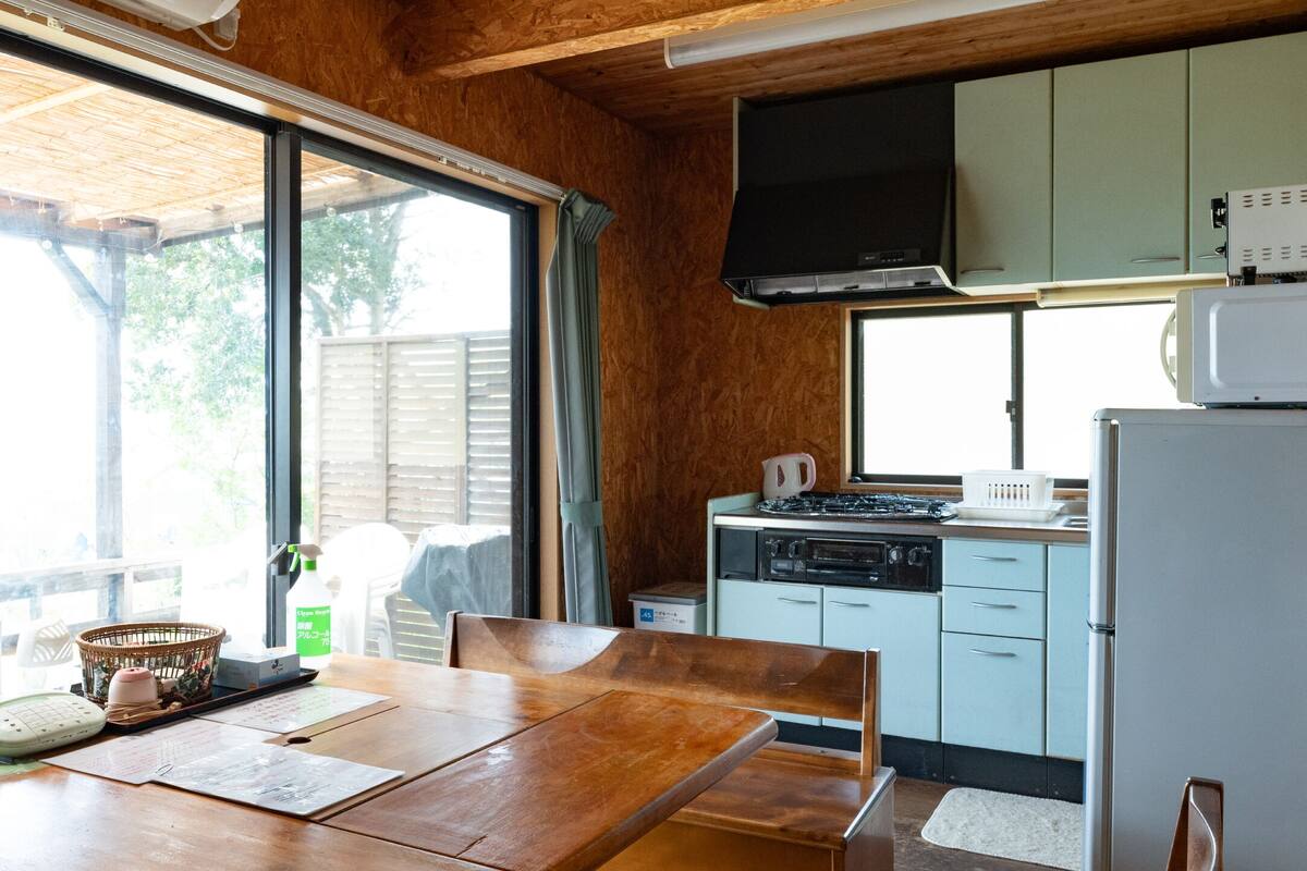 A compact kitchen with wooden cabinets, a microwave, and a stove.