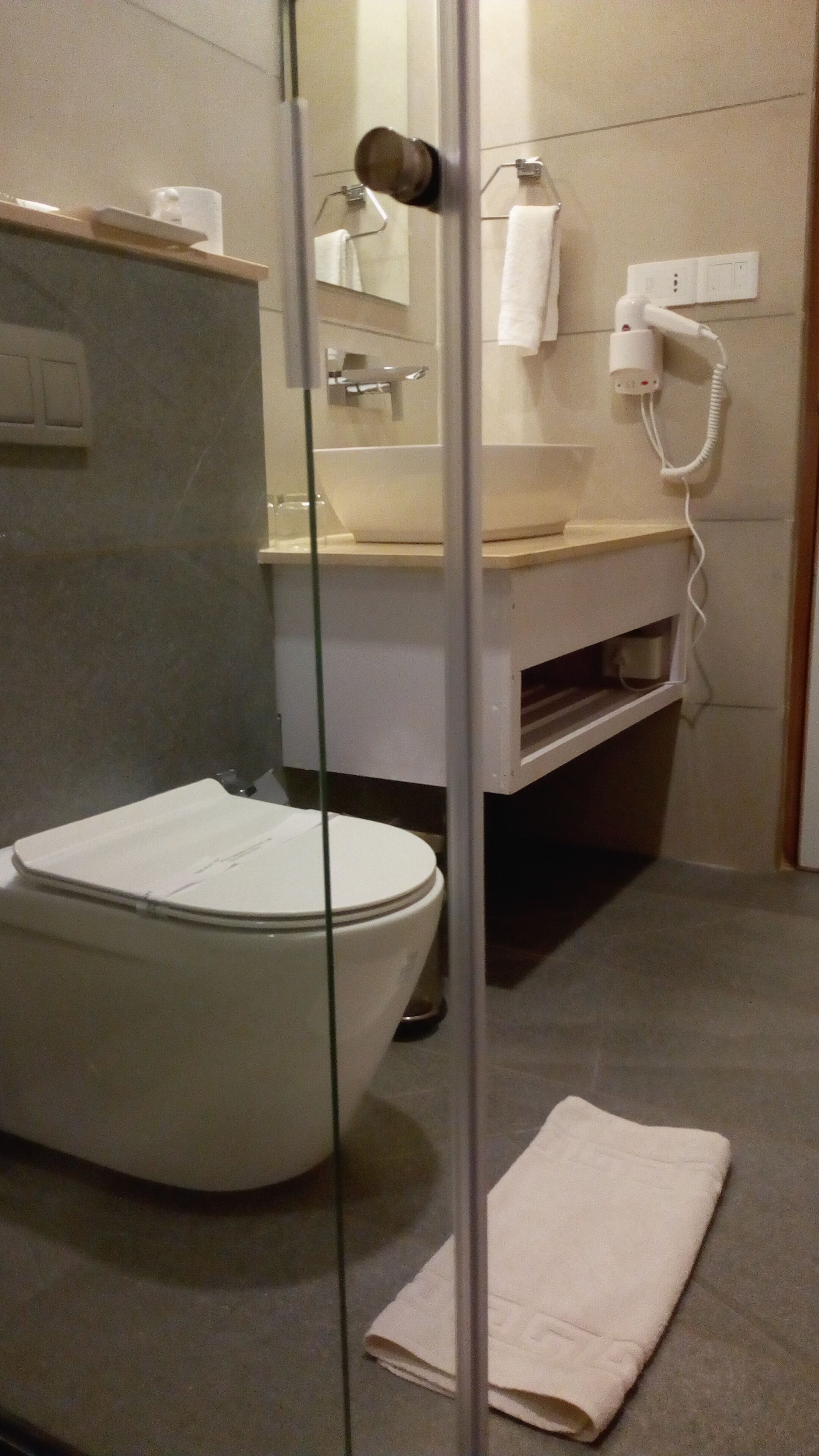 Ein modernes Badezimmer mit Toilette, Waschbecken und Duschbereich.