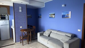 Un espace de vie compact comprenant une kitchenette, un coin repas et un canapé.