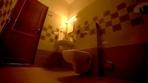 Une salle de bain avec des toilettes, un lavabo et un miroir.