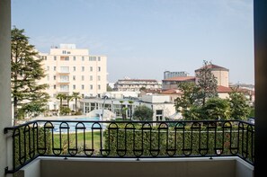 Varanda com grade de metal que dá para área residencial com edifícios e piscina.