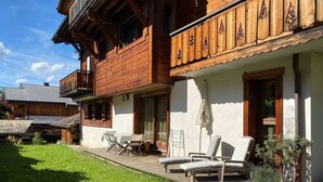 A wooden chalet with a balcony, outdoor seating, and a well-maintained lawn. - Top location in the resort center with easy access to slopes (Morzine)
