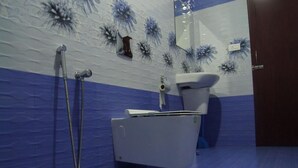 A bathroom with a white toilet, a shower, and a sink. - Green Island Resort (Vaikom)