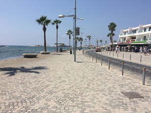 A paved promenade with palm trees, street lamps, and a view of the sea. - Modern 2 bed apartment situated in the Universal Area of Paphos (Paphos)