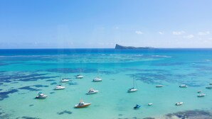 On peut clairement voir une zone côtière avec de nombreux bateaux ancrés dans des eaux turquoise.