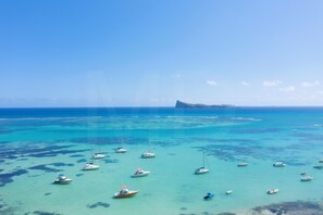 A clear view of a coastal area with multiple boats anchored in turquoise waters.