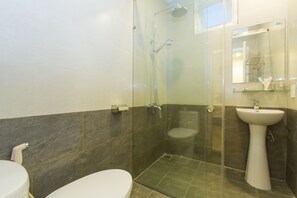 A modern bathroom with a glass-enclosed shower, a white sink, and a toilet. - Pebble Homestay (Da Nang)