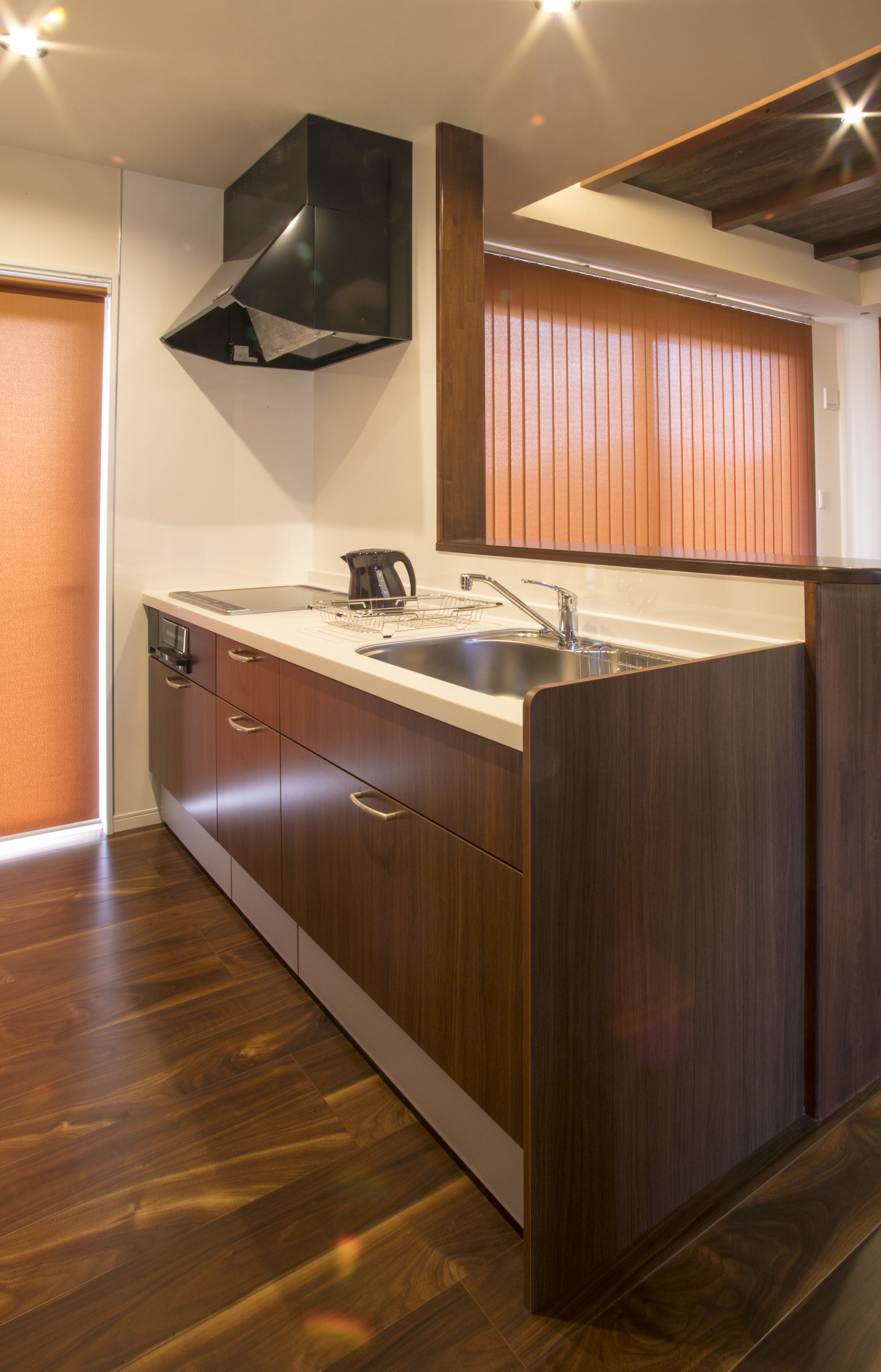 A modern kitchen with wooden cabinets, a stainless steel sink, and a built-in range hood.