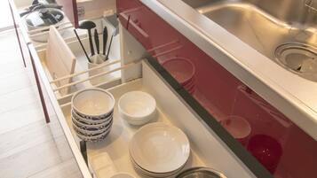 A modern kitchen with a stainless steel sink, a kettle, and a dish rack.